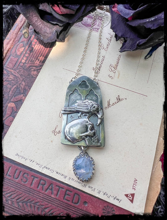 Haven Noir~Hand crafted sterling and fine silver cathedral window with raven perched on human skull with a rose cut rainbow moonstone droplet necklace ~
